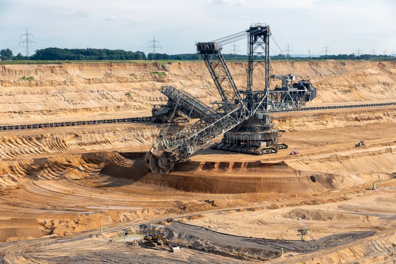 Brown coal open pit landscape with digging excavator in Germany stock images