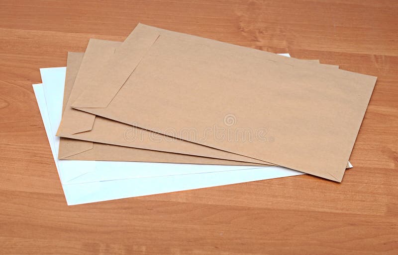 Brown and white envelopes on table. Brown and white envelopes on table