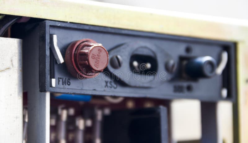 A brown fuse holder on the back panel of the old tape recorder stock images