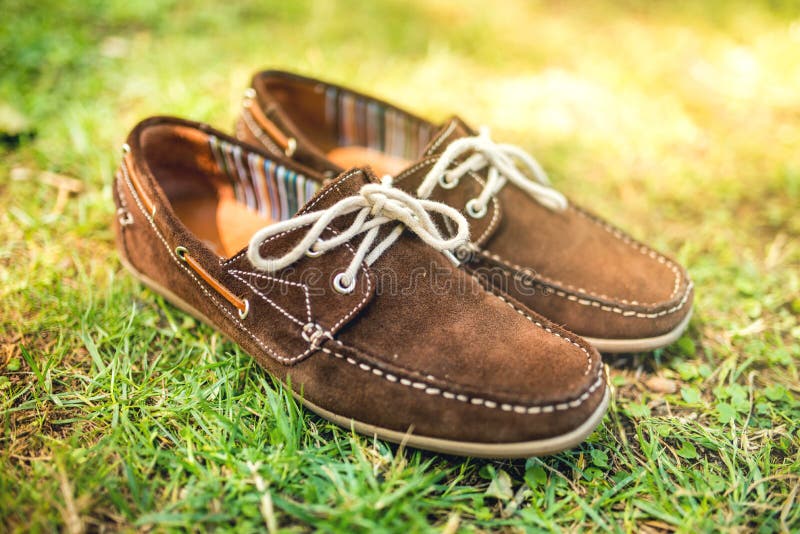 Brown garnissent en cuir les chaussures des hommes, mocassins élégants d'été dans l'herbe Les hommes façonnent, des accessoires d photo stock Brown garnissent en cuir les chaussures des hommes, mocassins élégants d'été dans l'herbe Les hommes façonnent, des accessoires d photo stock