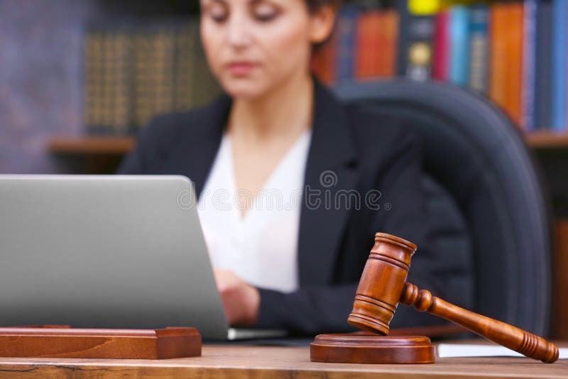 Brown gavel on wooden table and female lawyer stock photos Brown gavel on wooden table and female lawyer stock photos