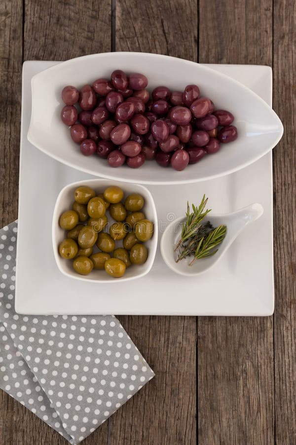 Brown and Green Olives by Vegetable and Cheese on Cutting Board Stock