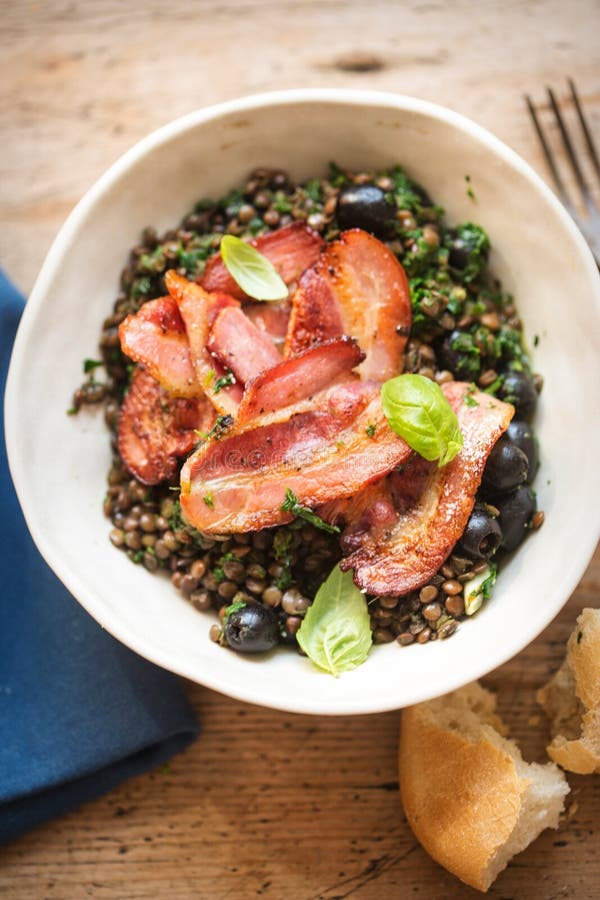 Brown Lentils with Spinach, Black Olives and Fried Bacon Stock Image