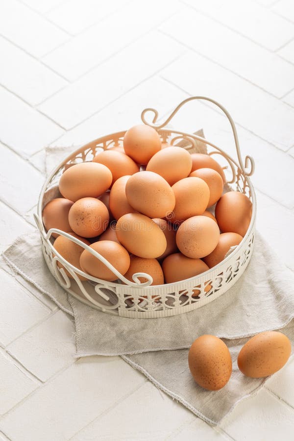 Brown organic eggs in a basket on kitchen table stock image