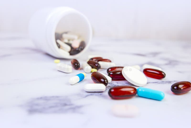 Brown, pillole blu e bianche, compresse e capsule sparsi su una base bianca con un fondo bianco immagine stock libera da diritti Brown, pillole blu e bianche, compresse e capsule sparsi su una base bianca con un fondo bianco immagine stock libera da diritti