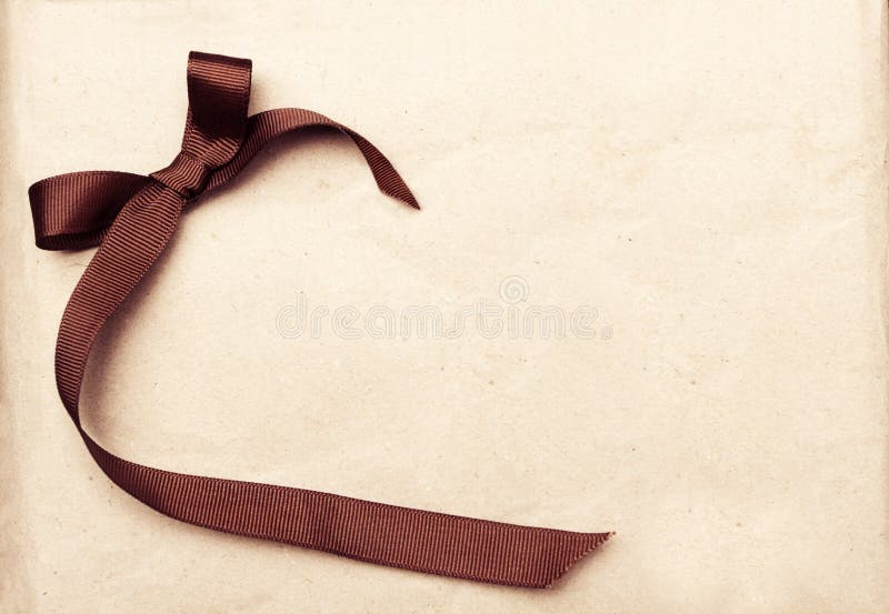 Brown ribbon over vintage gift old paper background stock images