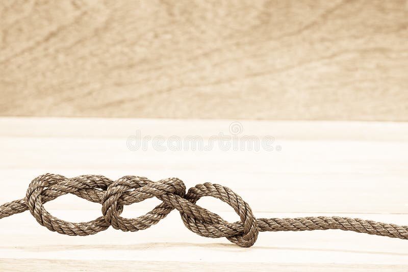 Brown rope knot on blurred wooden background stock photos