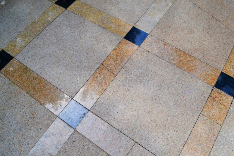 Brown smooth tile with a pattern of squares, close-up near the fountain. royalty free stock photography