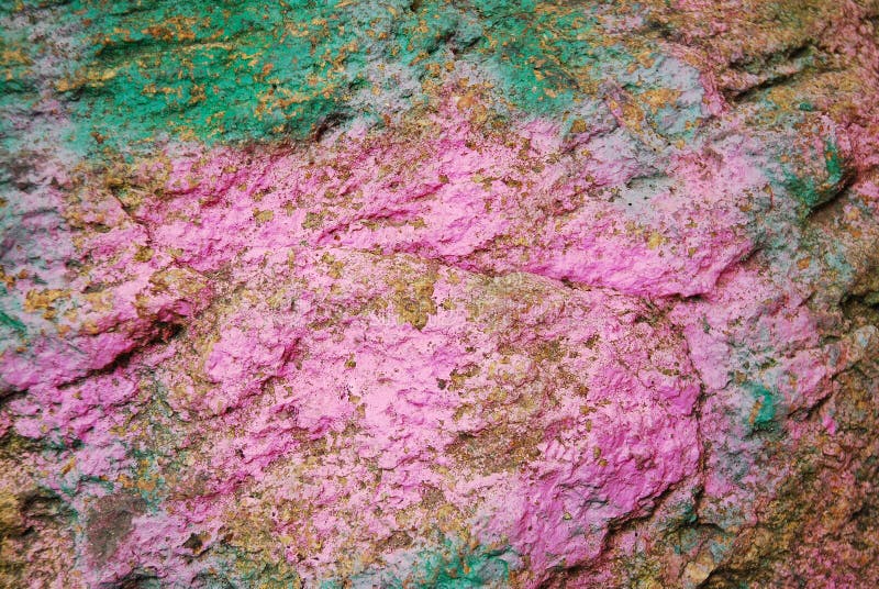 Brown Stone Painted with Paint in Pink and Green. Rock Background