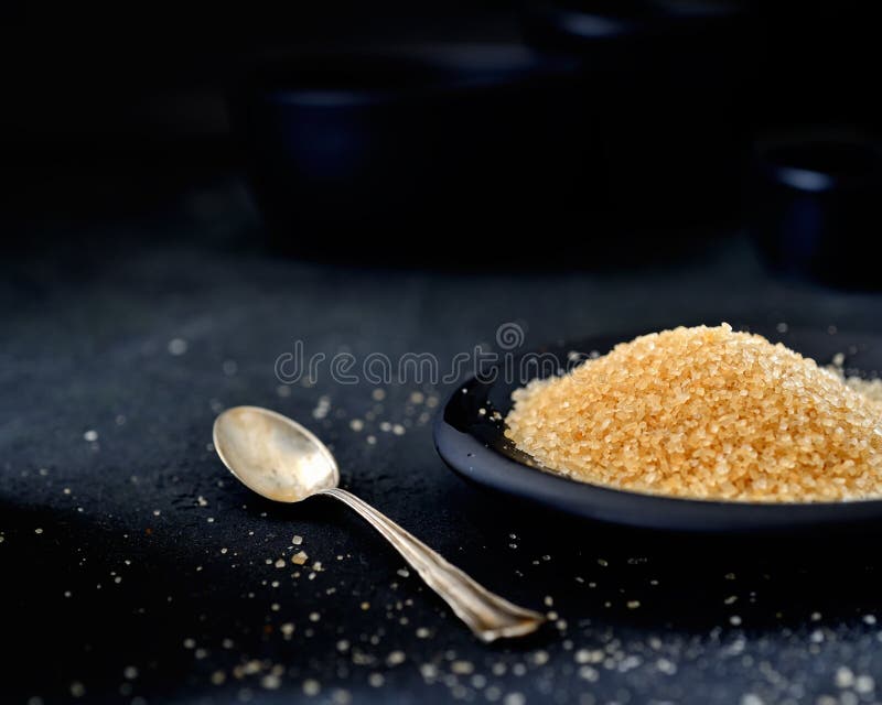 Brown Sugar in a Saucer, Vintage Teaspoon on a Black Background Stock