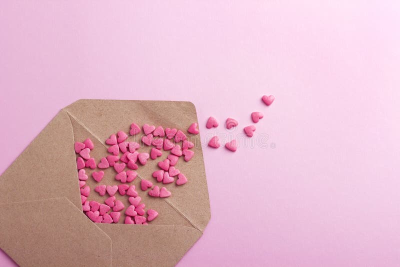Brown-Umschlag mit purpurroten Herzen auf rosa Papier- oder Papphintergrund lizenzfreie stockbilder Brown-Umschlag mit purpurroten Herzen auf rosa Papier- oder Papphintergrund lizenzfreie stockbilder