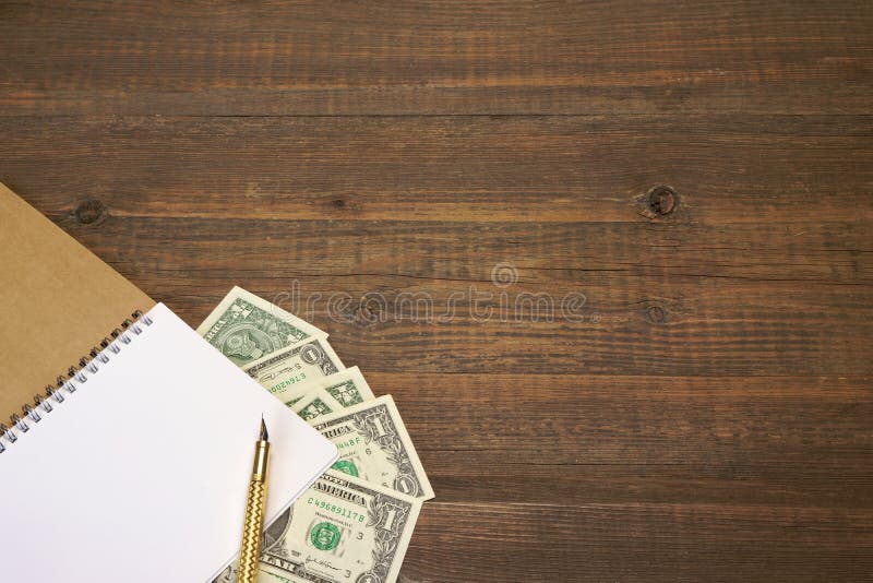 Brown Wood Table With Notebook, Money And Gold Ink Pen