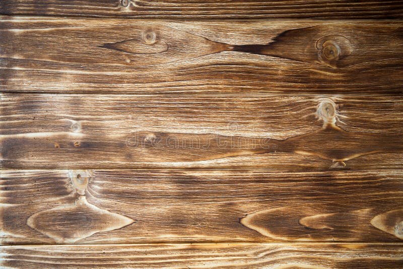 Brown, wooden board fence. Dark vintage wooden boards. Backgrounds and textures fence painted. Front view. Attract a royalty free stock photo Brown, wooden board fence. Dark vintage wooden boards. Backgrounds and textures fence painted. Front view. Attract a royalty free stock photo