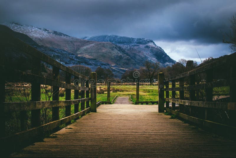 Brown Wooden Bridge Near Mountain at Daytime stock photo Brown Wooden Bridge Near Mountain at Daytime stock photo