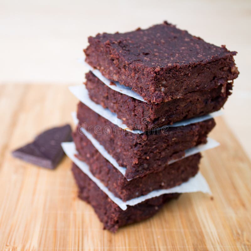 Brownie casalinghi del cioccolato impilati su beige fotografia stock libera da diritti Brownie casalinghi del cioccolato impilati su beige fotografia stock libera da diritti