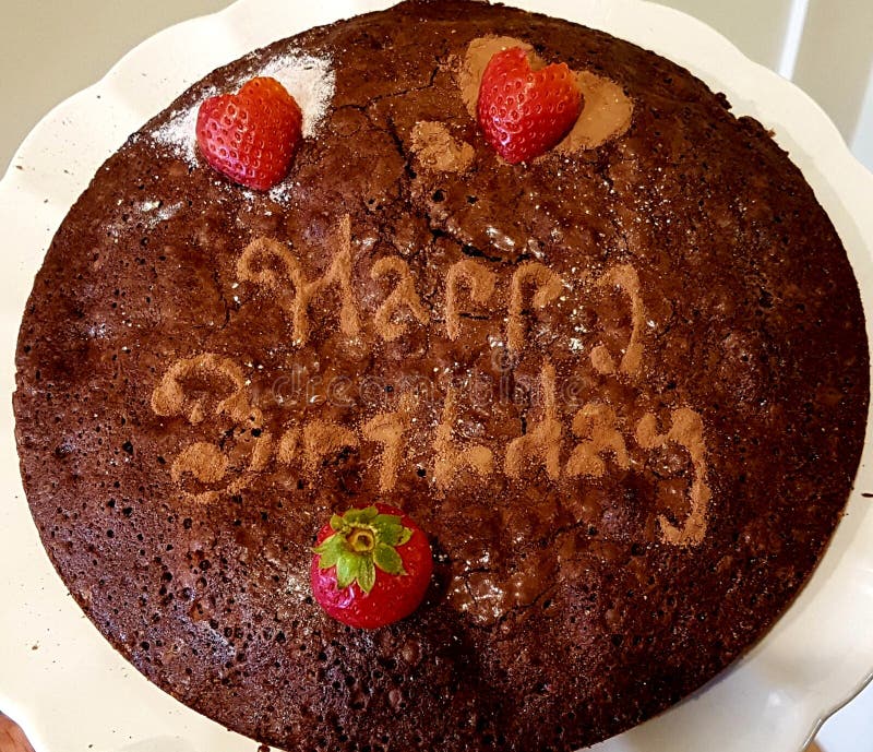 Brownie disguised as Birthday cake. Coco powder, confectioner`s powder and fresh strawberries were used to dress up the brownie. Stensil made the job easy royalty free stock images Brownie disguised as Birthday cake. Coco powder, confectioner`s powder and fresh strawberries were used to dress up the brownie. Stensil made the job easy royalty free stock images