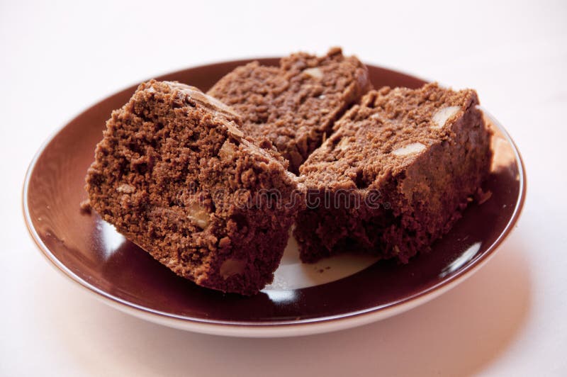 Three portions of brownie on a brown plate. Dessert portions stock images, royalty-free photos and pictures