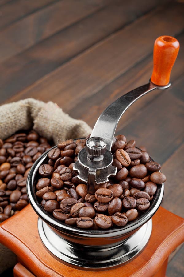 Coffee grinder with coffee beans on wooden table. Coffee grinder with coffee beans on wooden table