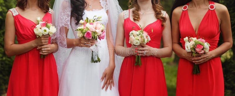 Bruden och brudtärnor i rosa klänningar står rak hållande bou royaltyfri fotografi Bruden och brudtärnor i rosa klänningar står rak hållande bou royaltyfri fotografi