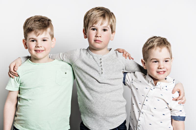 Bruder mit drei Freunden zusammen auf weißem Hintergrund des Studios stockfoto