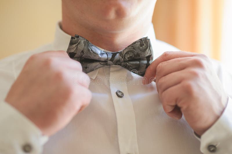 Brudgum som gör en Bowtie justering arkivbilder Brudgum som gör en Bowtie justering arkivbilder
