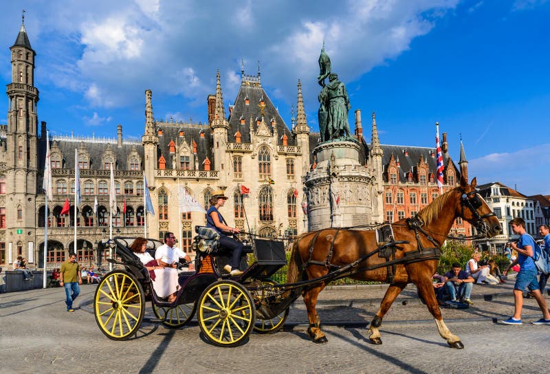 BRUGES, BELGIUM - 7 AUGUST 2014. Horse carriage on Grote Markt square. Belgian city of Bruges (Brugge) is UNESCO world heritage listed for its medieval center.