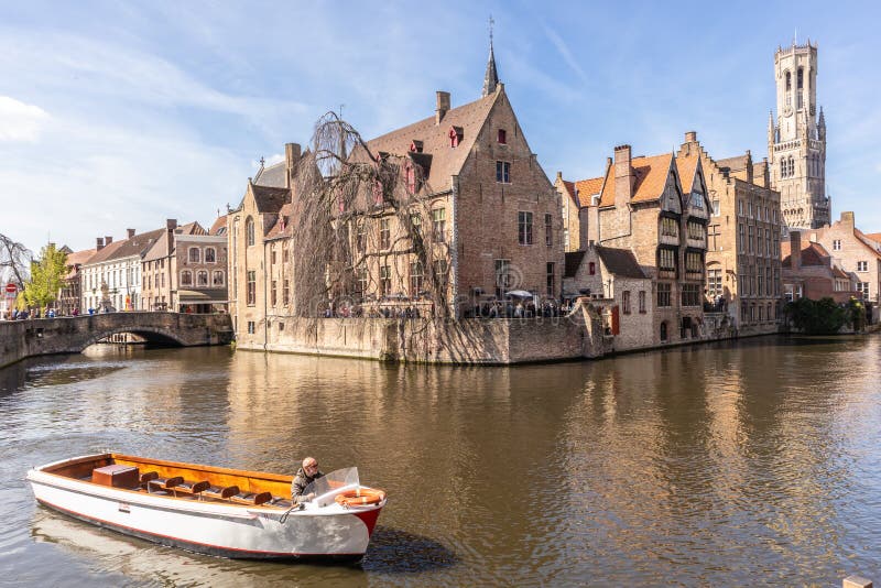 Brugge, Belgi? - APRIL 05, 2019: Reisboot die toeristen nemen door de mooie stad van Brugge door het kanaal stock afbeeldingen Brugge, Belgi? - APRIL 05, 2019: Reisboot die toeristen nemen door de mooie stad van Brugge door het kanaal stock afbeeldingen