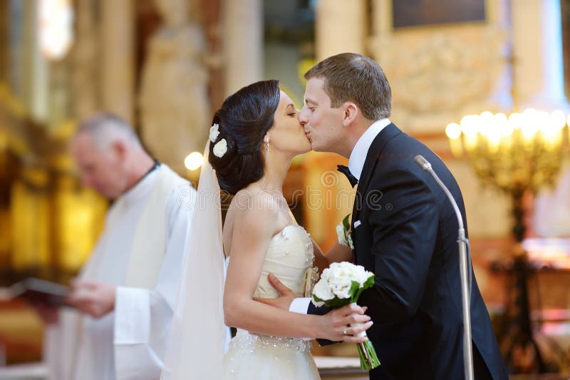 Bruid en bruidegom het kussen in een kerk royalty-vrije stock fotografie Bruid en bruidegom het kussen in een kerk royalty-vrije stock fotografie