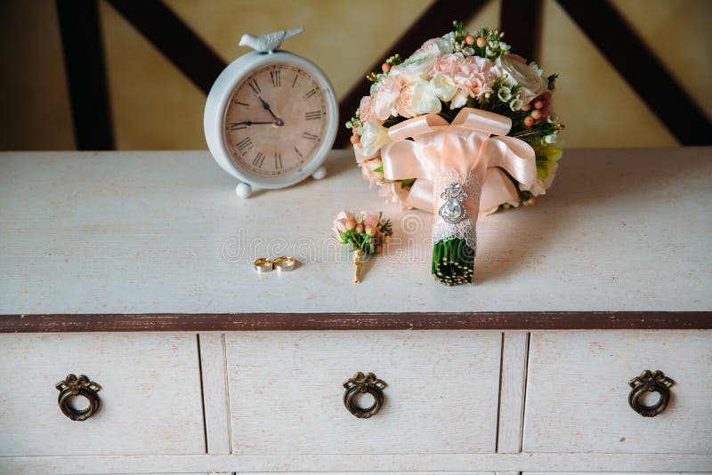 Bruid in witte kleding Boutonniere, Gouden ringen, een mooi boeket van bloemen op witte geweven lijst Concept bruid stock foto's Bruid in witte kleding Boutonniere, Gouden ringen, een mooi boeket van bloemen op witte geweven lijst Concept bruid stock foto's