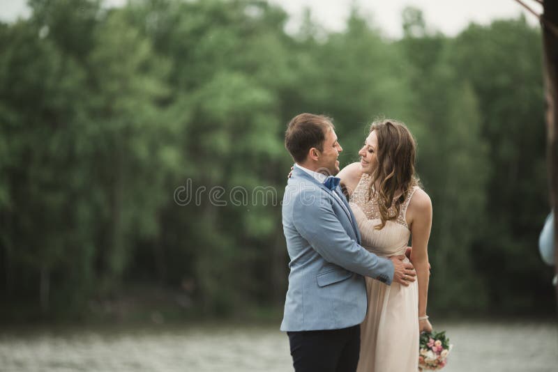 Bruidegom dragende bruid dichtbij meer en bos royalty-vrije stock afbeelding Bruidegom dragende bruid dichtbij meer en bos royalty-vrije stock afbeelding