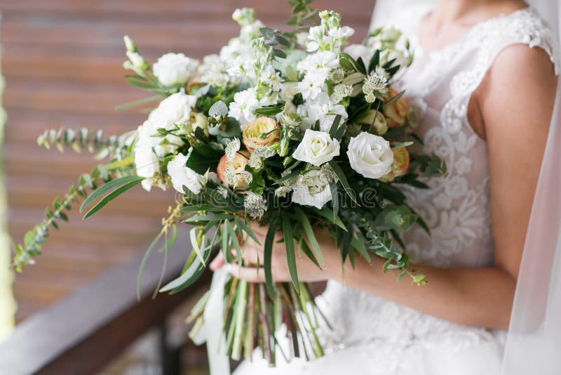 Bruids boeket De bruid ` s Mooi van wit die bloemen en groen, met zijde wordt verfraaid ligt het lint, op wijnoogst royalty-vrije stock fotografie Bruids boeket De bruid ` s Mooi van wit die bloemen en groen, met zijde wordt verfraaid ligt het lint, op wijnoogst royalty-vrije stock fotografie