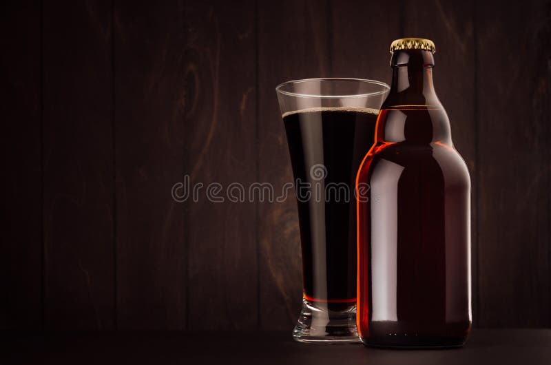 Bruin Belgisch steinie en glas pilsener van de bierfles met omhoog portier op donkere houten raad, exemplaarruimte, spot stock foto's Bruin Belgisch steinie en glas pilsener van de bierfles met omhoog portier op donkere houten raad, exemplaarruimte, spot stock foto's