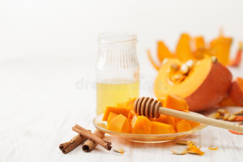 Bruiné avec le potiron de miel coupez en morceaux dans le plat, le miel et la cannelle photographie stock libre de droits Bruiné avec le potiron de miel coupez en morceaux dans le plat, le miel et la cannelle photographie stock libre de droits