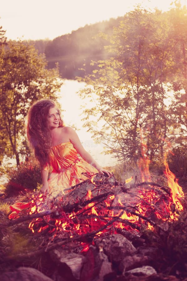 Bruja de la belleza en el bosque cerca del fuego Mujer mágica que celebra fotografía de archivo Bruja de la belleza en el bosque cerca del fuego Mujer mágica que celebra fotografía de archivo