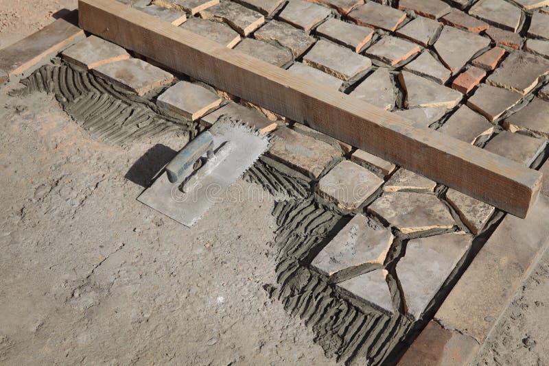 Old tiles recycling, making terrace or pavement using tile pieces, mortar and tile adhesive, with trowel tool. Old tiles recycling, making terrace or pavement using tile pieces, mortar and tile adhesive, with trowel tool