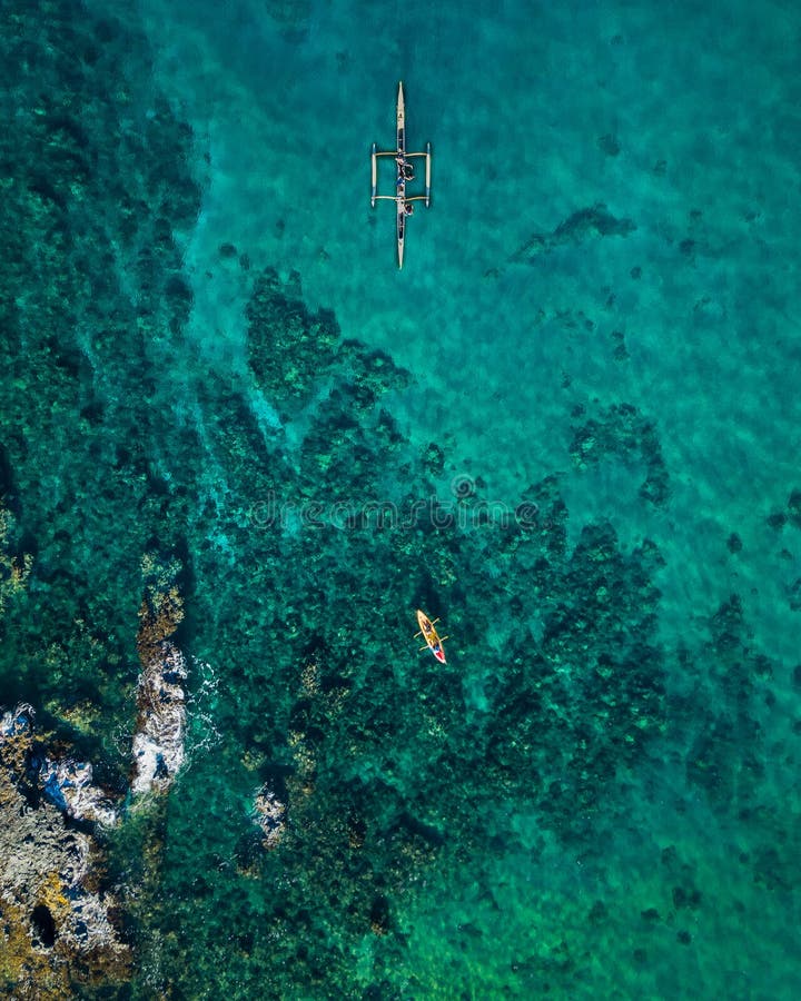 Brummenspitze hinunter Ansicht einer Person, die im klaren blauen Knickentenwasser Kayak fährt lizenzfreie stockbilder Brummenspitze hinunter Ansicht einer Person, die im klaren blauen Knickentenwasser Kayak fährt lizenzfreie stockbilder