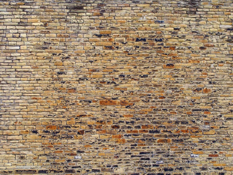 Brun och gul utomhus- stenvägg med många ojämna grova tegelstenar och texturerad yttersida arkivbilder Brun och gul utomhus- stenvägg med många ojämna grova tegelstenar och texturerad yttersida arkivbilder
