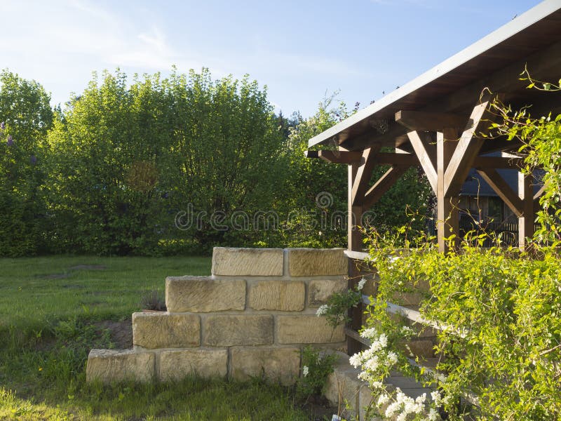 Brun tiber trägazebo eller pergola med klättringväxter och wh arkivbild Brun tiber trägazebo eller pergola med klättringväxter och wh arkivbild