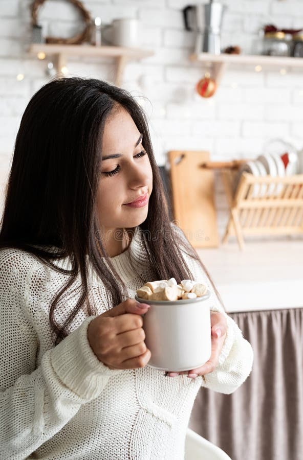 Brunetka trzymająca filiżankę piankowego kakao w kuchni obraz stock