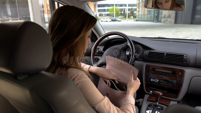 Brunetki dziewczyny obsiadanie w samochodzie i gmeranie dzwonimy w jej kiesie, tylny widok zdjęcie royalty free Brunetki dziewczyny obsiadanie w samochodzie i gmeranie dzwonimy w jej kiesie, tylny widok zdjęcie royalty free