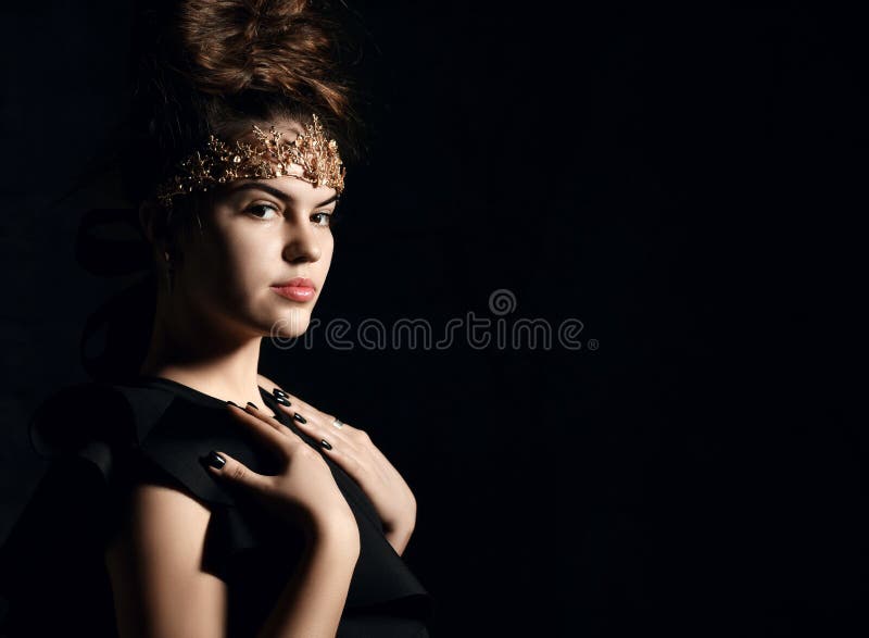 Brunetta attrattiva con una corona d'oro sulla corona di tiara sulla fronte con capelli alla trave in un corpo nero e intelligent fotografie stock libere da diritti