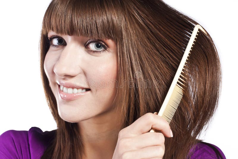 Brunette brushing her hair, in studio