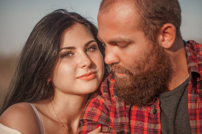 Brunette e brutale ragazzo con una storia d'amore alla barba. abbracci e fotografie stock libere da diritti
