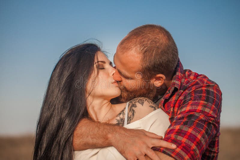 Brunette e brutale ragazzo con una storia d'amore alla barba. abbracci e fotografia stock libera da diritti