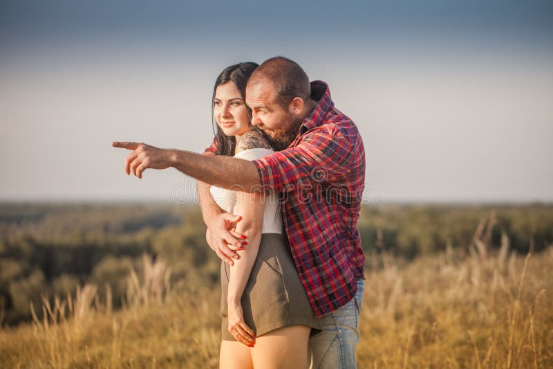 Brunette e brutale ragazzo con una storia d'amore alla barba. abbracci e fotografia stock