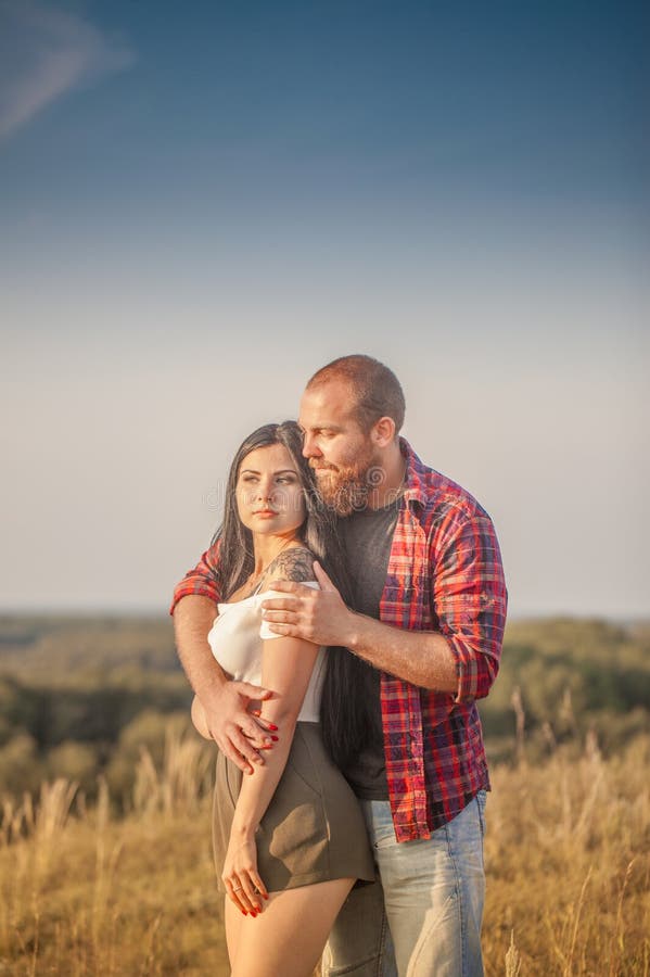Brunette e brutale ragazzo con una storia d'amore alla barba. abbracci e fotografia stock libera da diritti