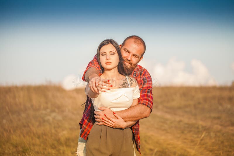 Brunette e brutale ragazzo con una storia d'amore alla barba. abbracci e fotografia stock libera da diritti