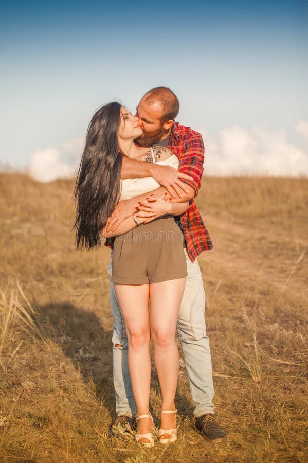 Brunette e brutale ragazzo con una storia d'amore alla barba. abbracci e fotografia stock libera da diritti