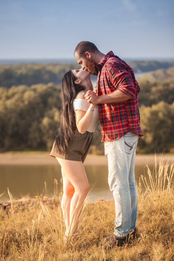 Brunette e brutale ragazzo con una storia d'amore alla barba. abbracci e fotografia stock