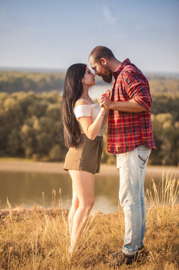 Brunette e brutale ragazzo con una storia d'amore alla barba. abbracci e fotografia stock